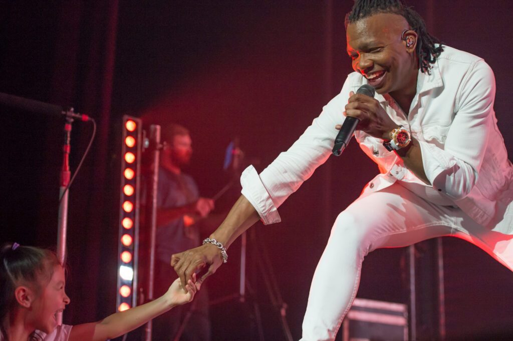Newsboys Michael Tait interacts with young fan from stage.